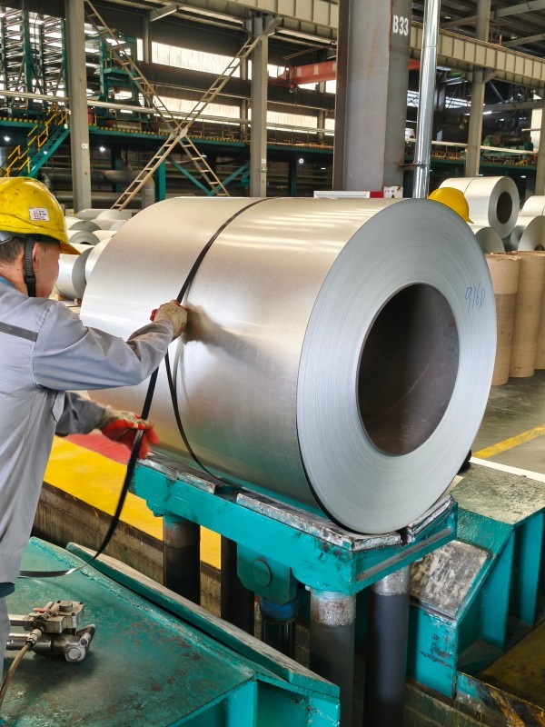 Worker processing steel coil in China manufacturing facility